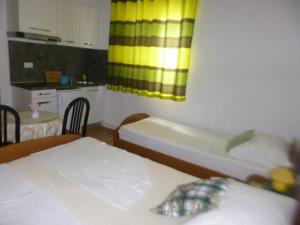 a room with two beds and a kitchen with a sink at Haus Pehar in Baška Voda