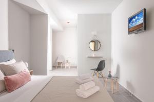 a bedroom with white walls and a bed with pink pillows at Golden Sunlight Hotel by Estia in Gouves