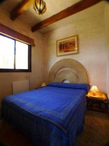 a bedroom with a blue bed and a fan at Chalet La Ahumada - Piscina y golf in Tarifa +41 photos