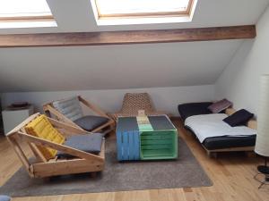 a attic room with chairs and a bed at Sweet home 2 in Charleroi