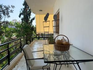 a balcony with a glass table and a basket of fruit at Vintage 70s flat in Athens