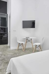 a white room with a table and two chairs at FERIA MODERN y LUXURY in Seville