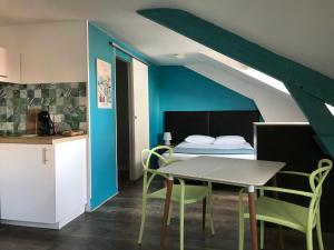 a room with a bed and a table and chairs at Mosaikhotel in Saint-Jean-de-Luz