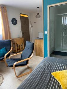 1 dormitorio con 2 sillas y 1 cama en Gîte L'EAU VIVE, en Noyers