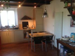 Una cocina con mesa y sillas y una ventana. en Monolocale Suvereto, en Suvereto 2 fotos más