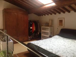 Un dormitorio con una cama y un armario de madera. en Monolocale Suvereto, en Suvereto