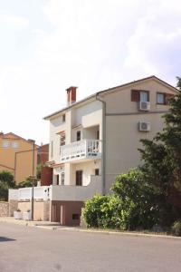 a white building with a balcony on the side of it at One-Bedroom Apartment Novi Vinodolski near Sea 7 in Povile
