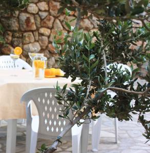 a tree in front of a table with a white chair at One-Bedroom Apartment Novi Vinodolski near Sea 7 in Povile