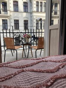 a balcony with two chairs and a table with flowers at Petite Visite No 18A i 18B in Toruń