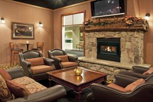 sala de estar con chimenea, sillas y mesa en Days Inn by Wyndham Warren, en Warren