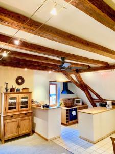 a large kitchen with wooden ceilings and wooden beams at Gite "Le Muscat" à Riquewihr in Riquewihr