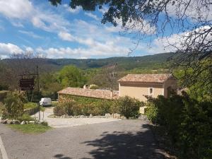 a house with a car parked next to a road at "Les Lauriers" chambre d'hôtes indépendante avec terrasse privée in Moustiers-Sainte-Marie