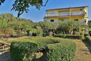 a large yellow house with a garden and a playground at Apartment Lopar, Primorje-Gorski Kotar 2 in Lopar
