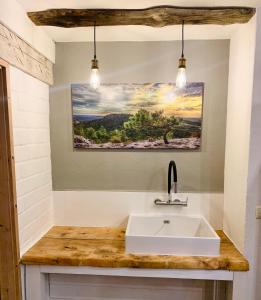 een badkamer met een wastafel en een schilderij aan de muur bij Casa Enrico in Oberjoch