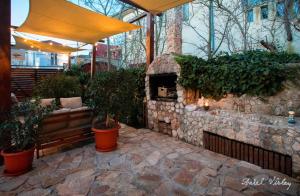 an outdoor patio with a stone fireplace with plants at Casa de la Mare in Vama Veche