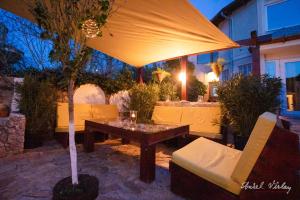 a patio with a table and an umbrella at Casa de la Mare in Vama Veche