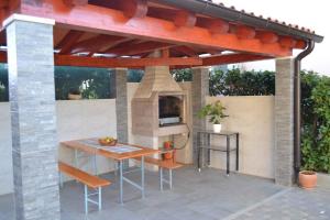 an outdoor kitchen with a pizza oven on a patio at Apartment Valbandon 3 in Štinjan