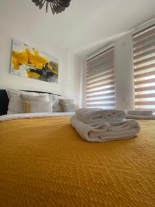 ein Bett mit einer orangefarbenen Decke darüber in der Unterkunft La Siesta Apartment in Zlatibor