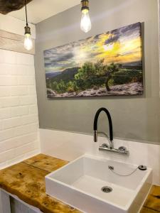 a bathroom with a sink and a painting on the wall at Summit Alps Apartments - Inclusive Bergbahntickets in Oberjoch +22 photos
