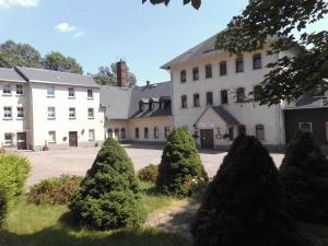 a large white building with trees in front of it at Apartment Sayda 1 in Pilsdorf