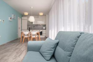a living room with a blue couch and a kitchen at Apartments Dva Galeba in Bol