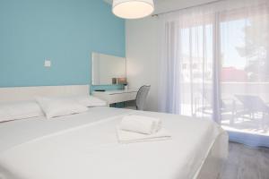 a white bedroom with a white bed and a window at Apartments Dva Galeba in Bol