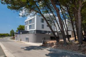 un bâtiment blanc sur le côté d'une rue dans l'établissement Apartments Dva Galeba, à Bol