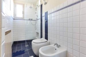 a white bathroom with a toilet and a sink at Massimiliano apartment in center with AC in Lucca