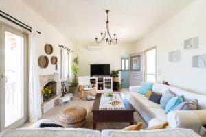 a living room with a white couch and a fireplace at Parasporos Villa - Private Pool - Beach Access in Parasporos