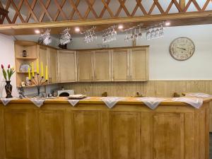 a bar in a room with a clock on the wall at G Penzion in Spišská Belá