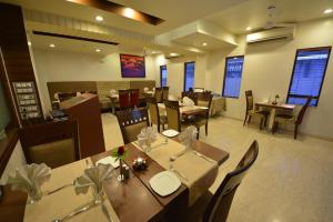 ein Esszimmer mit Tischen und Stühlen in einem Restaurant in der Unterkunft The Legend Inn @Nagpur in Nagpur