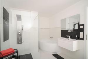 een witte badkamer met een wastafel en een toilet bij Designapartments Business and More - Sennhütte 9 in Wernigerode