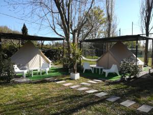 eine Gruppe von Zelten mit Stühlen und einem Tisch in der Unterkunft Camping Smeraldo in Trevignano Romano