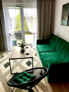 a living room with a green couch and a table at Apartament na Skrzypka in Cieszyn