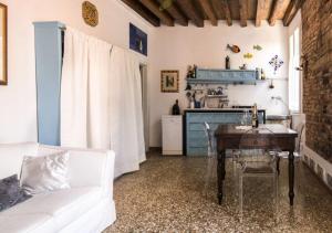 ein Wohnzimmer mit einem Tisch und einem weißen Sofa in der Unterkunft Venice Giardini Biennale Apartment in Venedig + 8 Fotos