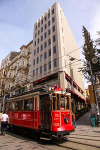 a red trolley car on a street in front of a building at Taksim Seya Suites Hotel in Istanbul