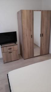 um armário com uma televisão e um espelho num quarto em Casa Elena Eselnita em Eşelniţa