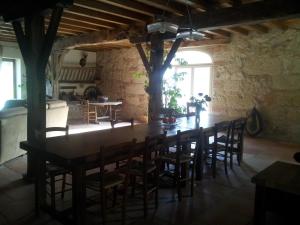 uma sala de jantar com uma grande mesa de madeira e cadeiras em Chambre d'Hôtes Le Moulin d'Encor em Seysses-Savès