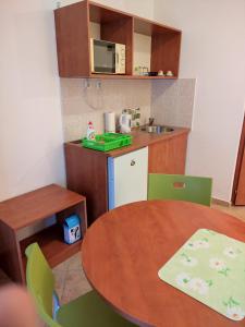une petite cuisine avec une table, une table et des chaises dans l'établissement Szent Kristóf Apartmanhotel, à Zalaegerszeg