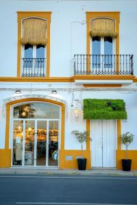 een gebouw met twee ramen en twee planten op een straat bij DONDE DUERME EL GUADIANA in Ayamonte