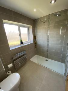 a bathroom with a tub and a toilet and a window at Sigurd House in Thurso