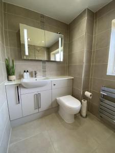 a bathroom with a toilet and a sink and a mirror at Sigurd House in Thurso