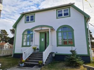 a white house with a green door at Missionshuset Bed & Breakfast in Sandhamn