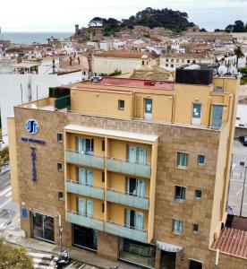 an apartment building in front of a city at Hotel Turissa in Tossa de Mar