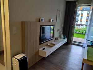 a living room with a flat screen tv in a cabinet at Bel Mare Patio and Garden C108 in Międzyzdroje