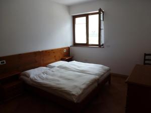 a bedroom with a white bed with a window at Agritur Maso Fontane in Arco