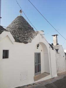 un bâtiment blanc avec un toit et une porte dans l'établissement Luxury Trulli sabotino, à Alberobello