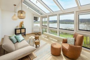 a living room with a lot of windows at Stille x Weite - Hochwertige Wohnung mit See-Panorama in Kronburg