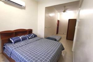 Un dormitorio con una cama con almohadas azules. en Mersing Fun Beach Home Services en Mersing