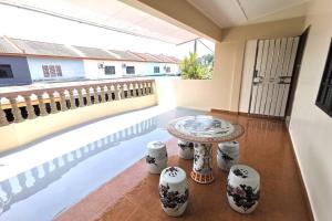 a living room with a table and a balcony at Mersing Fun Beach Home Services in Mersing